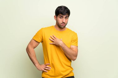 Pembe duvar üzerinde genç adam sürpriz ve doğru bakarken şok