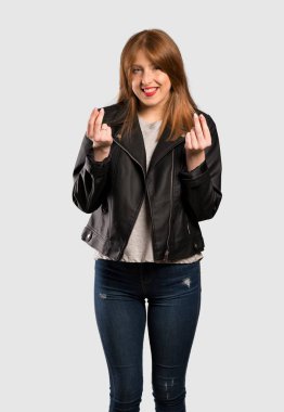 Genç Redhead kadın izole gri arka plan üzerinde para jest yapma