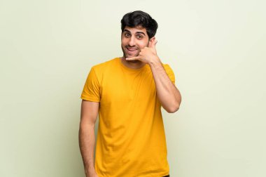 Pembe duvar telefon jest yapma genç adam. Bana arka işareti de