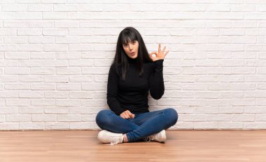 Kadın yerde oturan şaşırttı ve ok işareti gösteren