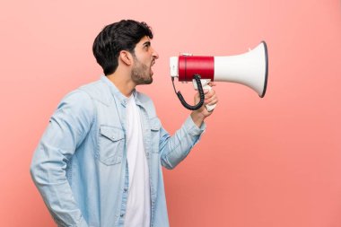 Genç adam bir megafon ile bağırarak pembe duvarın üzerinden