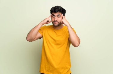 Pembe duvar üzerinde şüphe ve düşünme sahip genç adam