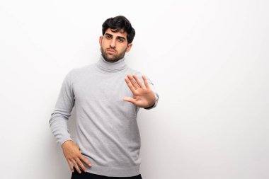 İzole beyaz duvar üzerinde genç adam stop jest yapma