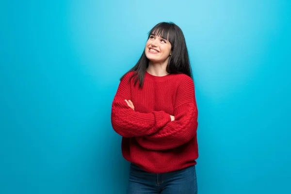 Vrouw Met Rode Trui Blauwe Muur Opzoeken Terwijl Glimlachen — Stockfoto