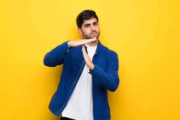 Sarı Duvar Üzerinde Mavi Ceket Olan Adam Zaman Aşımına Jest — Stok fotoğraf