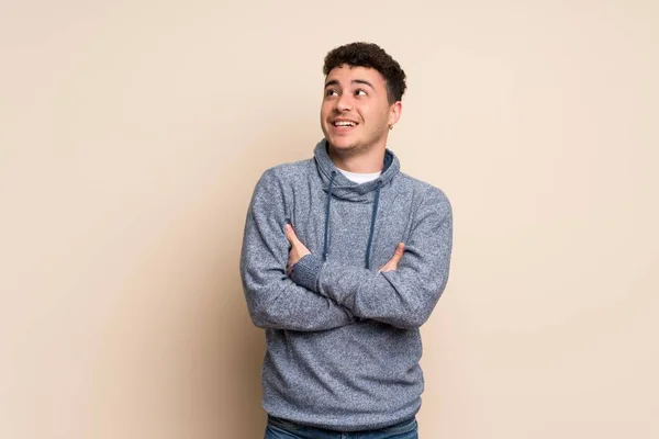 Jeune Homme Sur Mur Isolé Levant Les Yeux Tout Souriant — Photo