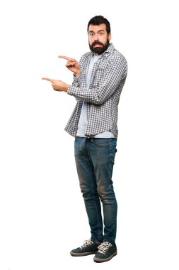 Korkmuş ve izole beyaz arka plan üzerinde tarafına işaret sakallı yakışıklı adam