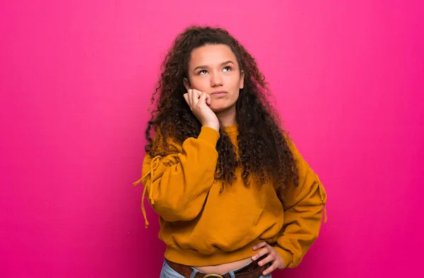 Adolescente Chica Sobre Rosa Pared Teniendo Dudas —  Fotos de Stock