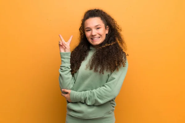 Adolescente Chica Sobre Ocre Pared Sonriendo Mostrando Signo Victoria —  Fotos de Stock