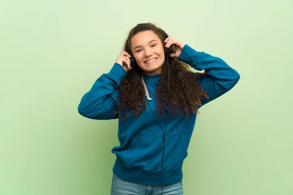 Tiener Meisje Groene Muur Luisteren Naar Muziek Met Een Koptelefoon — Stockfoto