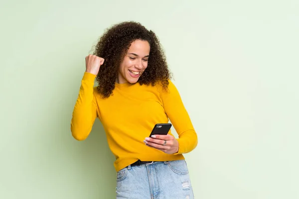 Femme Dominicaine Sur Fond Vert Isolé Avec Téléphone Position Victoire — Photo