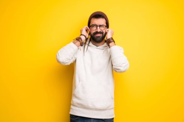 Hippi adam elleriyle kulaklarını kapsayan dreadlocks ile. Hayal kırıklığı ifade