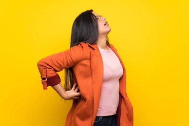 Bir çaba yapılmış olması için sırt ağrısı muzdarip sarı duvarın üzerinden Kolombiyalı genç kız