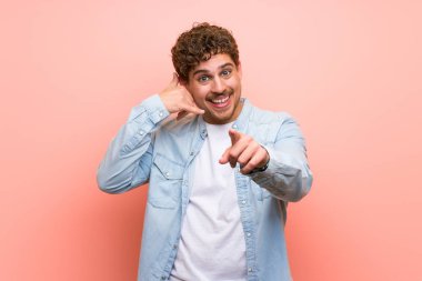 Sarışın adam telefon jest yapma ve açık işaret pembe duvar üzerinde