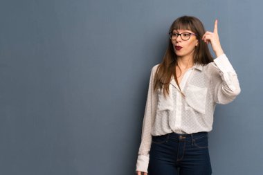 Parmak kaldırma sırasında çözüm mavi duvar niyetinde üzerinde gözlüklü kadın anlar