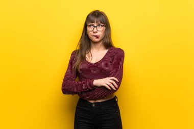 Kadın gözlük ile karıştırmayın yüz ifadesi ısırıkları dudak iken sarı duvarın üzerinden