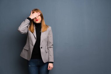 Kızıl saçlı bir iş kadını gözleri eller tarafından kapsayan. Bir şey görmek istiyor musunuz