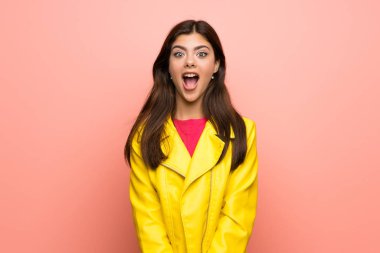 Genç kız sürpriz yüz ifadesi ile pembe duvar üzerinde