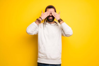 Hippi erkek gözler eller tarafından kapsayan dreadlocks ile. İleride ne olduğunu görmek için sürpriz