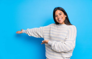 Kazak geri işaret ve bir ürün sunan genç Kolombiyalı Kız