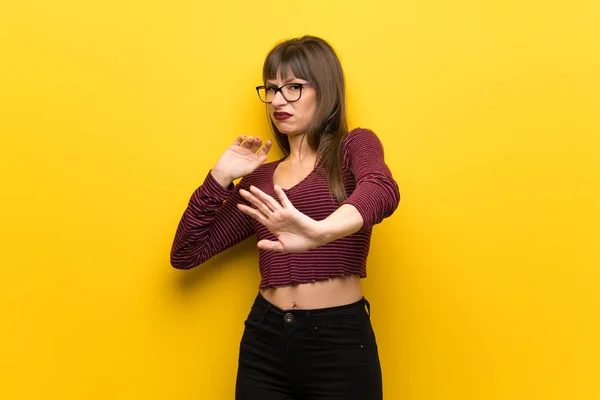 Vrouw Met Een Bril Gele Muur Nerveus Bang Stretching Handen — Stockfoto