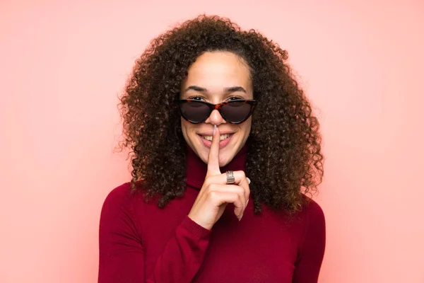 Dominican woman with turtleneck sweater doing silence gesture