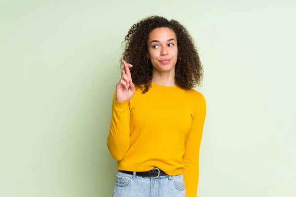 Dominicana Mulher Sobre Isolado Fundo Verde Com Dedos Cruzando Desejando — Fotografia de Stock