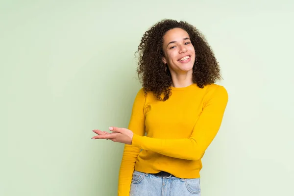 Mujer Dominicana Sobre Fondo Verde Aislado Presentando Una Idea Mientras —  Fotos de Stock