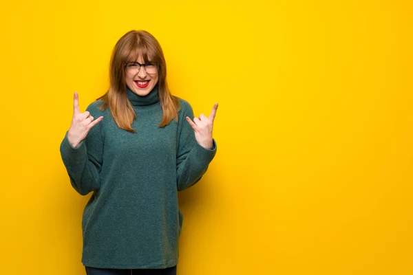 Kobieta Okularach Żółty Ścianę Dokonywanie Rock Gest — Zdjęcie stockowe