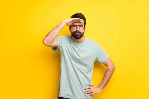 Homem Com Barba Camisa Verde Olhando Para Longe Com Mão — Fotografia de Stock