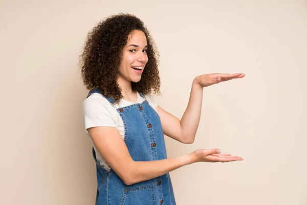 Dominikanische Frau Mit Overalls Die Kopierraum Für Eine Anzeige Hält — Stockfoto