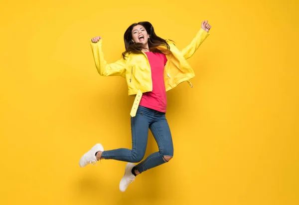 Dospívající dívka, která skočila přes izolované žluté zeď — Stock fotografie