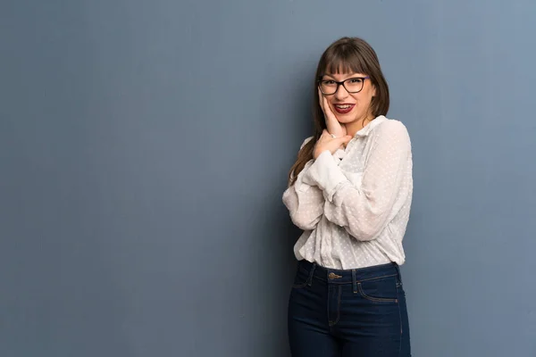 Mujer Con Gafas Sobre Pared Azul Sonriendo Con Una Dulce — Foto de Stock