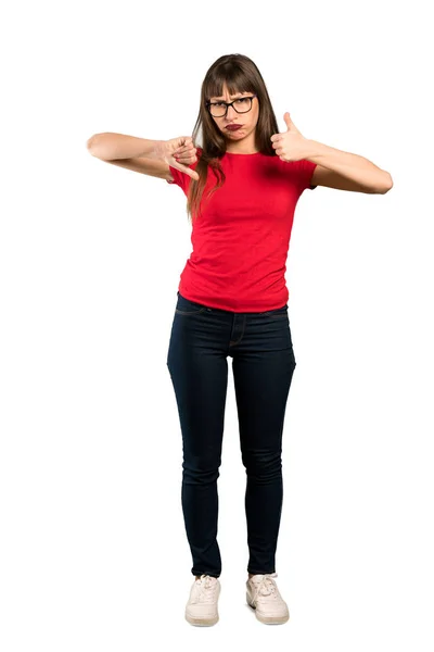 Full-length shot of Woman with glasses making good-bad sign. Undecided between yes or not