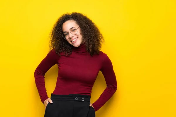 Dominican woman with turtleneck sweater with glasses and smiling