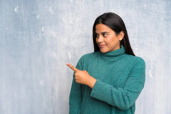 Junge Kolumbianische Mädchen Über Grunge Wand Zeigt Mit Dem Finger — Stockfoto