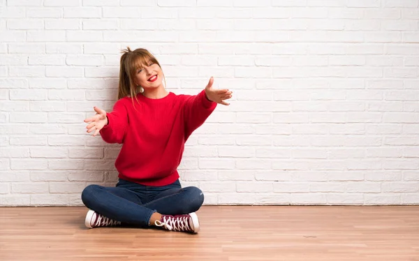 Rothaarige Frau Sitzt Auf Dem Boden Und Präsentiert Und Lädt — Stockfoto