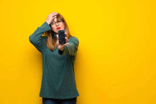 Žena Brýlemi Přes Žlutou Zeď Ustaranou Hospodářství Rozbité Smartphone — Stock fotografie