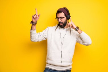 Dreadlocks ile hippi adam kulaklık ve dans ile müzik dinlerken