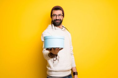 Dreadlocks ile hippi adam elinde bir hediye tutan