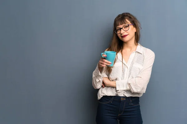 Donna Con Gli Occhiali Sopra Parete Blu Con Una Tazza — Foto Stock