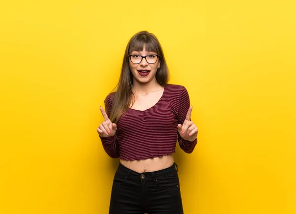 Vrouw Met Bril Gele Muur Wijzen Met Wijsvinger Een Geweldig — Stockfoto