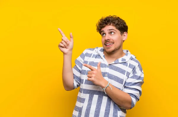 Hombre Rubio Sobre Pared Amarilla Señalando Con Dedo Índice Mirando — Foto de Stock