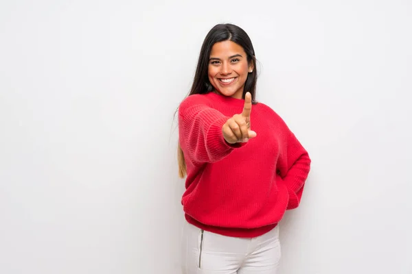 赤いセーターを持つ若いコロンビアの女の子が指を見せて持ち上げる — ストック写真