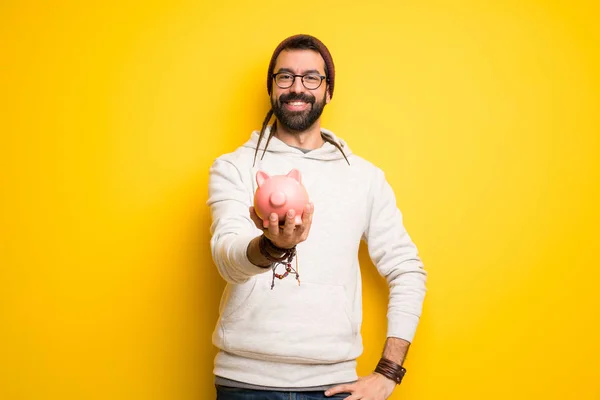 Hippie Man Med Dreadlocks Håller Piggybank — Stockfoto