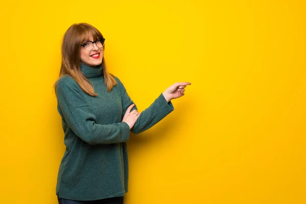 Frau Mit Brille Über Gelber Wand Zeigt Mit Dem Finger — Stockfoto