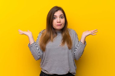 Genç kız sarı duvar eller yükselterek süre şüpheleri üzerinde