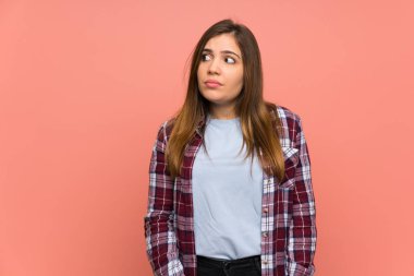 Genç kız pembe duvar yan seyir şüpheler jest yapma