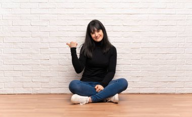 Ürün sunmak için tarafına işaret katta oturan kadın