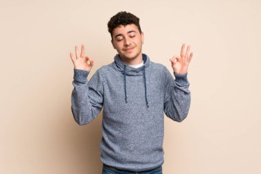 Zen izole duvar üzerinde genç adam poz